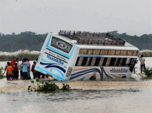 A private passenger bus is half-merged and struck due to floods after Cyclone Phailin triggered by heavy rains in the district of Kendrapada on Wednesday. PTI