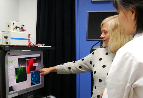 Dr. Maiken Nedergaard, left, points to images of brain scans of mice joined by her colleague Lulu Xie, of the University of Rochester Medical Center. The team, who observed the brains of mice during the sleep and awake states, has published a study in the journal Science that found the brain does a better job of clearing out cellular waste during sleep, a finding that may lead to new ways to treat Alzheimer's and other brain disorders. (AP Photo)