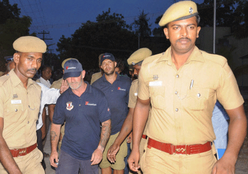 Policemen escort crew members of a U.S.-owned ship MV Seaman Guard Ohio outside a court in Tuticorin, in Tamil Nadu on Friday. Police arrested the crew on charges of illegally transporting weapons and ammunition in Indian waters. PTI Photo
