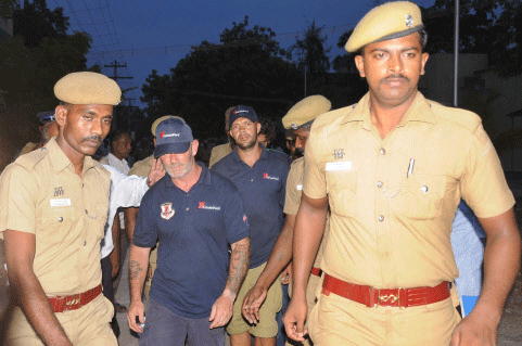 Policemen escort crew members of a U.S.-owned ship MV Seaman Guard Ohio outside a court in Tuticorin, in Tamil Nadu on Friday. Police arrested the crew on charges of illegally transporting weapons and ammunition in Indian waters. PTI Photo