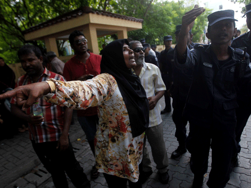 A supporter of presidential candidate Mohamed Nasheed, who was ousted as president in 2012, screams at a police officer as protesters try to block the road during a demonstration against the Maldives police, in Male October 19, 2013. Maldives police have stopped a fresh presidential poll that was to be held on Saturday, the archipelago's Election Commission said, despite a court ruling that the poll could go ahead. REUTERS