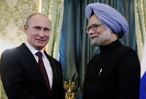 Prime Minister Manmohan Singh and Russian President Vladimir Putin shake hands at a meeting in Moscow on Monday. PTI Photo
