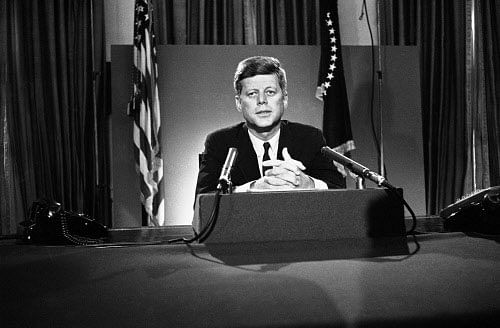 FILE - In this July 26, 1963 file photo, U.S. President John F. Kennedy sits behind microphones at his desk in Washington after finishing his radio-television broadcast to the nation on the nuclear test ban agreement initialed by negotiators in Moscow.  AP photo