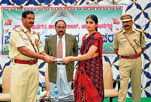 District Superintendent of Police P Rajendraprasad distributes compensation to the family of Gopalaswamy who died while on duty, in Chamarajanagar, on Monday. dh photo