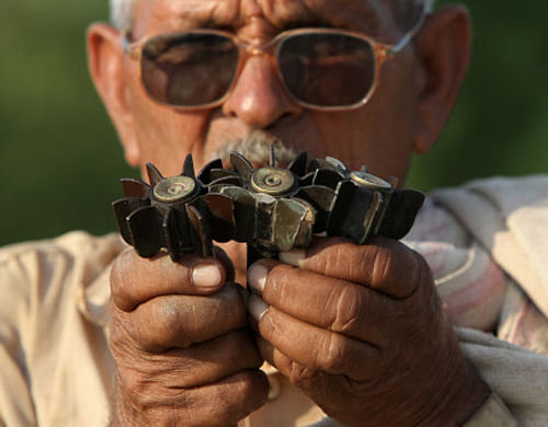 A villager shows mortar shells, that locals say are being fired from the Pakistan side of the international border, at a village in Samba sector, about 75 km (47 miles) from Jammu October 21, 2013. The firing and shelling along India's international border with Pakistan continues, local media reported on Monday. REUTERS