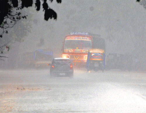 Poor visibility due to heavy rain obstructed movement of vehicles in Davangere on Tuesday. DH Photo