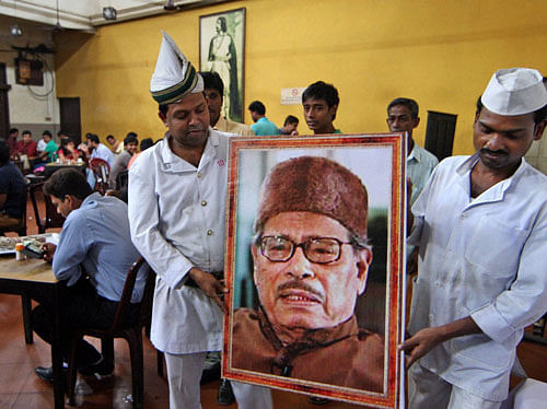Waiters carry a portrait of legendary singer Manna Dey to pay tributes to him at a coffee house in Kolkata on Thursday. Dey passed away on early Thursday morning at a Bengaluru hospital after a prolonged illness. PTI Photo