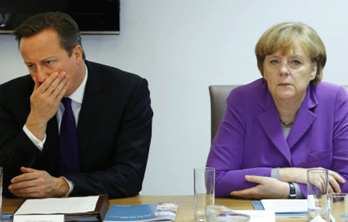 British Prime Minister David Cameron, left, and German Chancellor Angela Merkel participate in a meeting on the sidelines of an EU summit in Brussels on Friday, Oct. 25, 2013. Migration, as well as an upcoming Eastern Partnership summit, will top the agenda in Friday's meeting of EU leaders. AP
