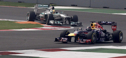 Greater Noida: Red Bull's Sabastian Vettel (R) and Petronas' Lewis Hamilton during the post qualifying session of the 2013 Formula 1 Indian Grand Prix at BIC in Greater Noida on Saturday. PTI Photo by Vijay Verma