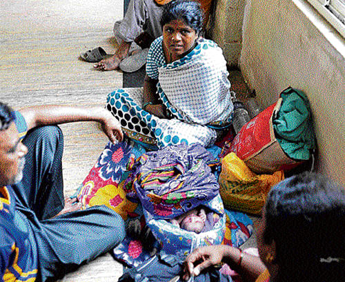 pathetic: Lack of adequate beds has forced this mother, her newborn and relatives to occupy the corridor of Vanivilas Hospital. dh Photo