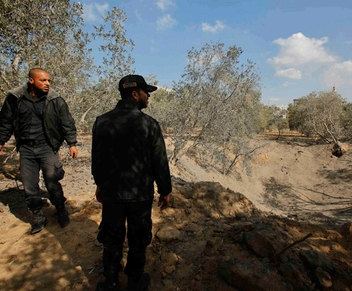 Palestinian policemen loyal to Hamas inspect the scene of an Israeli air strike in the northern Gaza Strip October 28, 2013. Palestinians in the Gaza Strip fired two rockets at a southern Israeli port city on Monday and Israel's Iron Dome interceptor shot down one while the other fell into the sea, a military spokeswoman said. Within hours, Israel's air force bombed what a military spokesman described as 'two rocket-launching tubes' in northern Gaza. There were no casualties. REUTERS