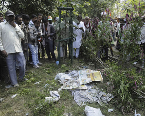 People gather very close to an unexploded bomb, hidden beneath newspapers before it was defused by officials outside the venue of a political rally in Patna, Sunday, Oct. 27, 2013. A series of small bomb blasts killed some people and injured dozens Sunday just hours before a campaign rally by the BJP's prime ministerial candidate Narendra Modi. AP Photo