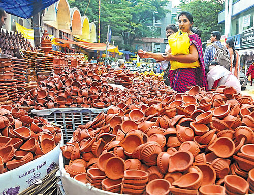 People purchase lamps a few days ahead of Deepavali festival in Bangalore on Monday. DH photo