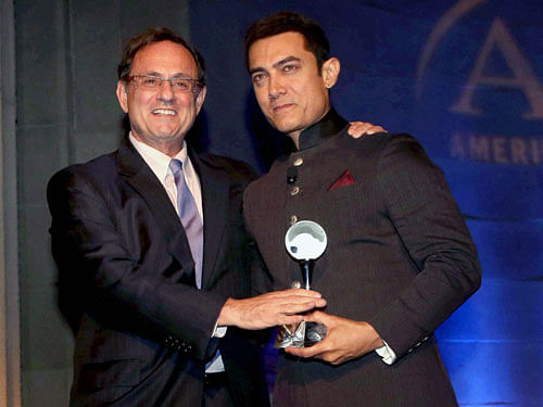 Douglas B Wilson, former Assistant Secretary of Defence for Public Affairs honours Bollywood actor Aamir Khan at America Abroad Media's 2013 Inaugural Awards Gala Dinner in Washington on Monday. PTI Photo