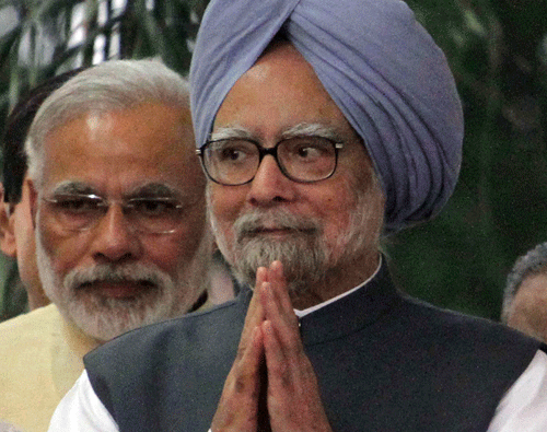 Prime Minister Manmohan Singh, front, greets the crowd as Gujarat state chief Minister Narendra Modi, left, stands behind him during the inauguration of the renovated memorial of Sardar Vallabhbhai Patel, one of the founding fathers of the Indian republic, in Ahmadabad, India, Tuesday, Oct. 29, 2013. Modi is the opposition Bharatiya Janata Party's (BJP) prime ministerial candidate for the 2014 general elections. (AP Photo