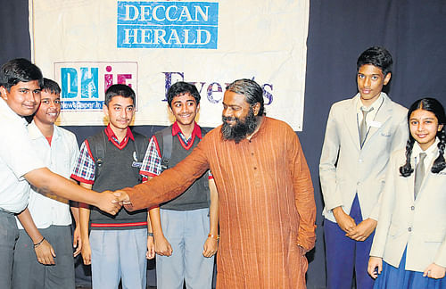 Quizmaster Arul Mani congratulates winners of DHiE quiz contest organised by Deccan Herald on Tuesday. DH PHOTO