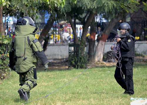 Bomb Disposal Squad members of NSG defusing a live bomb found at Gandhi Maidan in Patna. PTI
