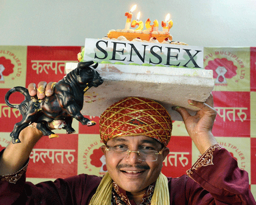 A share broker celebrates after Sensex surged to 21293, in Bhopal on Friday. PTI Photo