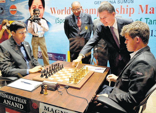 Rapt attention: FIDE President Kirsen Ilyumizhinov makes the first move during the FIDE World Chess Championship's opening match between Viswanathan Anand of India and  Magnus Carlsen of Norway on Saturday in Chennai. PTI