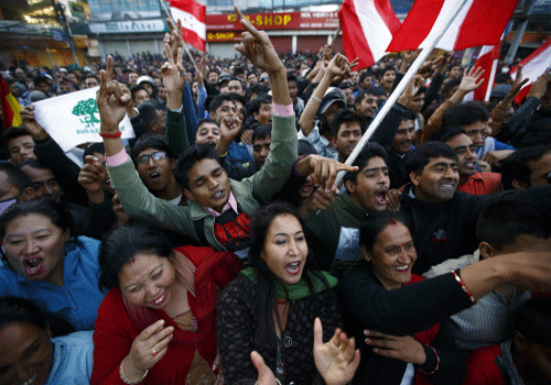 Supporters of Nepali Congress Party cheer for their party as Constituent Assembly Election scores are displayed on a screen outside the Constitution Assembly Building in Kathmandu November 20, 2013. Millions of Nepalis voted on Tuesday for an assembly that will draft a constitution aimed at ending years of instability but their ballots may not produce a conclusive result and could leave the country facing more turmoil. REUTERS