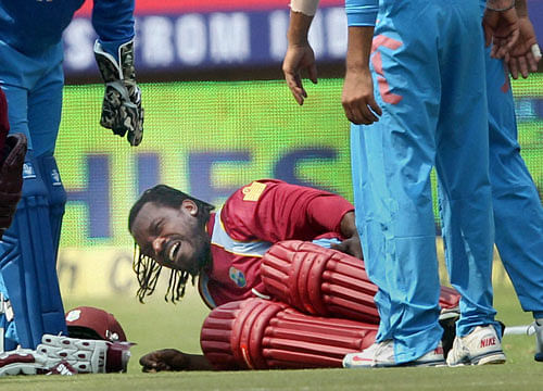Chris Gayle of West Indies writhes in pain after sustaining an injury while completing a run during the 1st ODI cricket match against India at Jawaharlal Nehru Stadium in Kochi on Thursday. PTI Photo