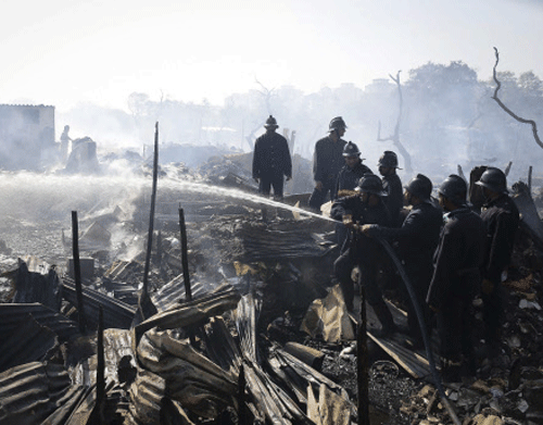 Fire fighters try to extinguish a fire in a slum area in Mumbai November 21, 2013. Several huts were gutted in the fire but no casualties were reported and the cause of the fire was unknown, local media reported on Thursday. REUTERS