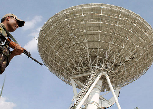 A paramilitary personnel stands guard near the 32-meter Deep Space Antenna  at Indian Deep Space Network in Byalalu, Bangalore on Wednesday.  DH PHOTO/B H Shivakumar