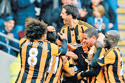 party starter: Hull City's Jake Livermore is mobbed by his team-mates after scoring the opener against Liverpool on&#8200;Sunday. REUTERS