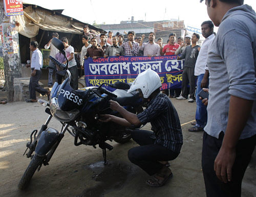 An activist of Bangladesh Jamaat-e Islami pours out petrol from his motorbike to set a fire on a street during a nationwide protest in Dhaka. Reuters file photo