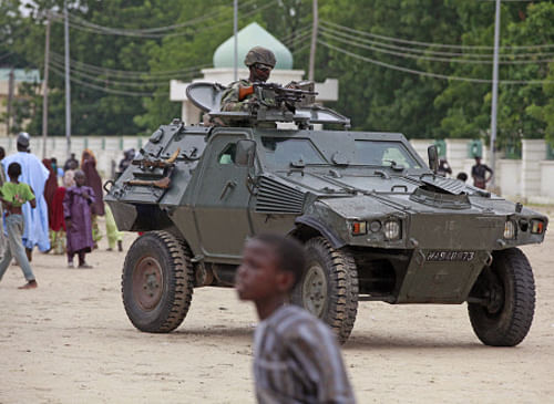 Nigerian soldiers ride in an armored car during a Eid al-Fitr celebration in Maiduguri, Nigeria. Hundreds of Islamic militants in trucks and a stolen armored personnel carriers attacked an air force base on the outskirts of a Nigerian city before dawn Monday, Dec. 2, 2013, officials and witnesses said, possibly leaving scores of people dead in one of the insurgent group's most daring attacks ever. (AP Photo)