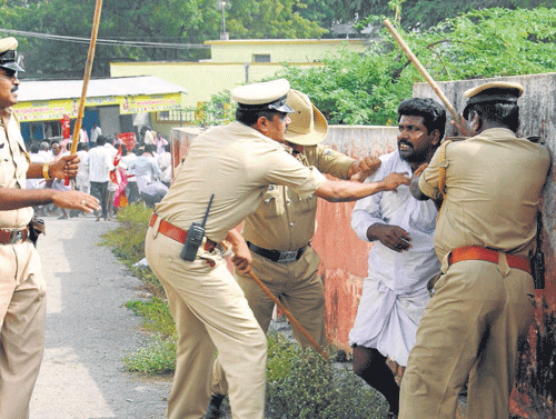 Police cane a farmer during a protest in Raichur on Monday.  KPN