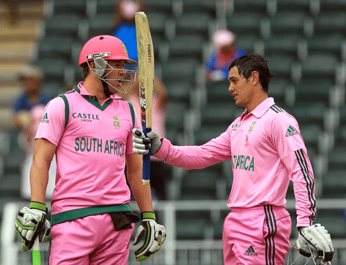 South Africa's Quinton de Kock, raises his bat after reaching a century as captain Abraham Benjamin de Villiers, left, watches during their 1st One Day International cricket match against India at Wanderers stadium in Johannesburg, South Africa, Thursday, Dec. 5, 2013. AP Photo