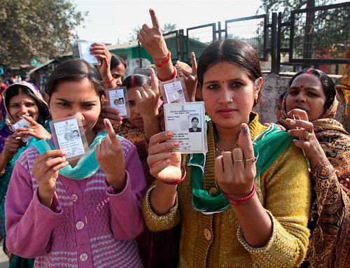 Women voters show their ink-marked fingers at a polling station after casting their votes for Delhi Assembly elections, at Tuglakabad in New Delhi on Wednesday. PTI Photo