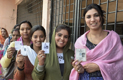 Woman voters show their voter identity cards at a polling station before casting their votes for Assembly elections in Bhopal, Madhya Pradesh on Monday. PTI Photo