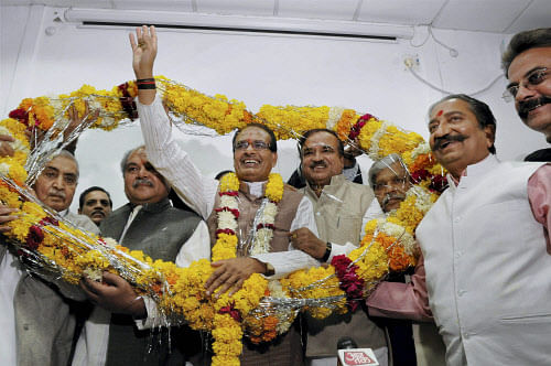 Bhopal: Madhya Pradesh Chief Minister Shivraj Singh Chouhan being garlanded by the party workers at his residence in Bhopal on Sunday after BJP's thumping victory in the State Assembly elections. AP