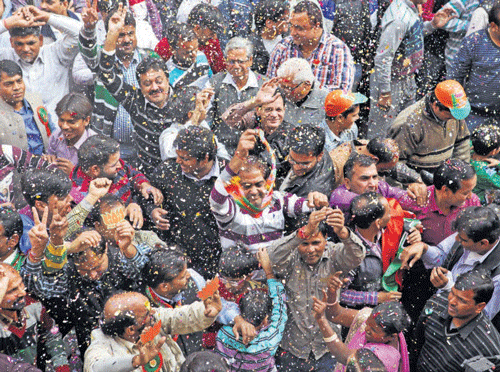 BJP workers celebrate the party's victory in the Delhi state Assembly elections in New Delhi on Sunday. AP