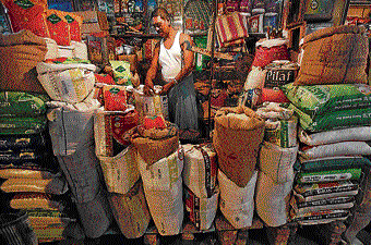 The owner of a kirana grocery store arranges a rice sack in Kolkata in this file photo. REUTERS