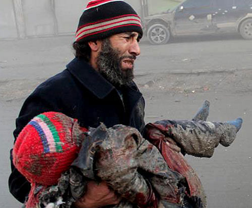 A Syrian man cries while holding the body of child who was killed following a Syrian government airstrike in Aleppo, Syria. AP Photo