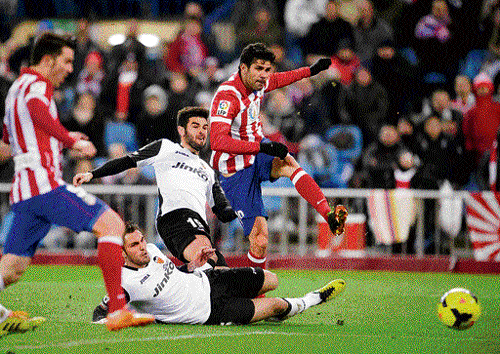 super finish: Diego Costa (right) outmuscles Valencia defenders to score during their La Liga clash on&#8200;Sunday. AFP