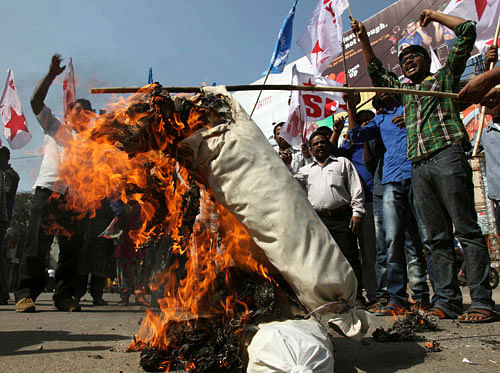 Left party activists burn an effigy of the U.S. to protest against the alleged mistreatment of New York based Indian diplomat Devyani Khobragade, in Hyderabad on Wednesday, Dec. 18, 2013. The Indian diplomat said she faced repeated 'handcuffing, stripping and cavity searches' following her arrest in New York City on visa fraud charges in a case that has infuriated the government in New Delhi. AP Photo