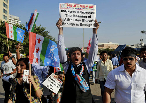 A member of the National Students Union of India (NSUI), the student wing of India's ruling Congress party, shouts slogans during a protest outside the U.S. consulate in Mumbai, India, Friday, Dec. 20, 2013. India's Information Minister Manish Tewari lashed out at the United States on Friday and demanded an apology for the treatment and arrest of Devyani Khobragade, India's deputy consul general in New York, saying America cannot behave 'atrociously' and get away with it. Meaning of 'Atithi Dev Bhavo' on placard is 'Guest is God'. AP Photo