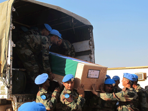 Soldiers from the peacekeeping force of the United Nations Mission in the Republic of South Sudan (UNMISS) receive the remains of two Indian military officers killed in the South Sudanese capital Juba in this December 20, 2013 handout picture. Two United Nations peacekeepers from India were killed and a third wounded on Thursday when a U.N. base in South Sudan was overrun by armed youths, U.N. spokesman Joe Contreras said on Friday. REUTER