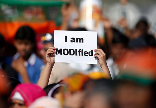 A supporter of Gujarat's chief minister Modi holds a placard during a rally in Mumbai Reuters