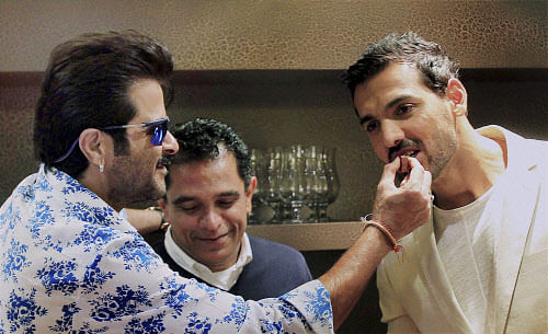 Bollywood actors John Abraham and Anil Kapoor with producer of film 'Welcome Back' Firoz Nadiadwala, celebrate their birthdays on sets of the film at a hotel in Dubai recently.PTI Photo