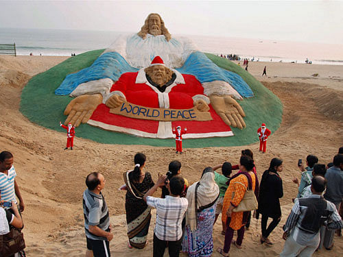 Sand artist Sudarsan Pattnaik sculpts the sand sculptor of Jesus Christ on a beach in Puri on the eve of Christmas. PTI Photo