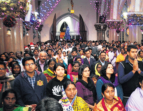 festival of joy: Devotees attend the mass at St Mary's Basilica in Shivajinagar on Tuesday night. (Below) A crib, depicting the birth of Jesus Christ, at the Basilica. dh Photos