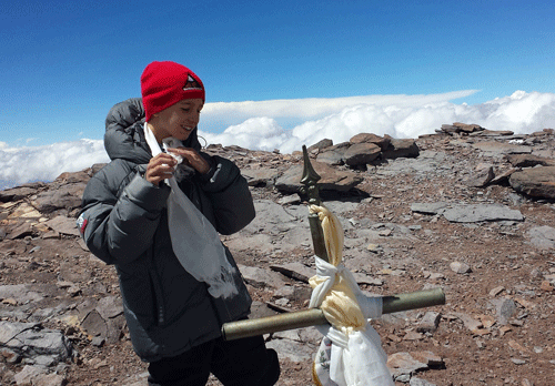 This Dec. 24, 2013 photo released by Lhawang Dhondup shows Tyler Armstrong, from Southern California, standing by a cross on the summit of Aconcagua Mountain in Argentina. The 9-year-old boy has become the youngest person in recorded history to reach the summit of Argentina's Aconcagua mountain, the tallest peak in the Western and Southern hemispheres. AP