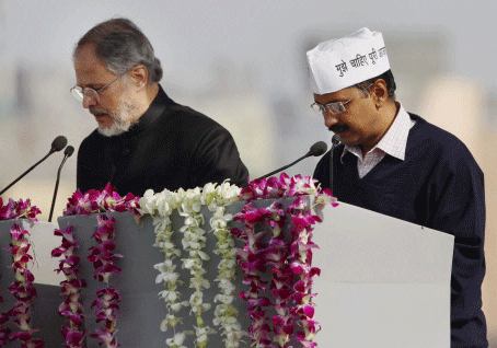 Lieutenant Governor Najeeb Jung administers the oath of office and secrecy to Arvind Kejriwal,Delhi Chief Minister, at Ramlila maidan in New Delhi on Saturday. PTI Photo