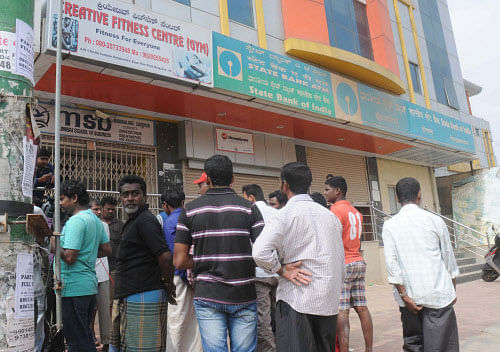 Onlookers gather in front an ATM kiosk at Hongasandra.  DH photo