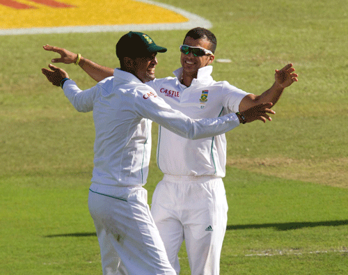 South Africa's Robin Peterson (L) and JP Duminy celebrate taking the wicket of India's Ravindra Jadeja (unseen) during the second day of the second cricket test match in Durban, December 27, 2013. Peterson is optimistic that his side could force a result on the final day of the second Test and win the series against India at Kingsmead, here. REUTERS